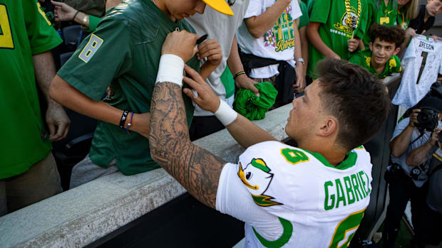 Oregon quarterback Dillon Gabriel autographs the shirt of Josiah Hansen as the Oregon State Beavers host the Oregon Ducks Sat