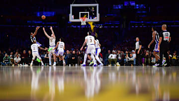 Dec 28, 2024; Los Angeles, California, USA; Sacramento Kings guard Malik Monk (0) shoots against Los Angeles Lakers guard D'Angelo Russell (1) and guard Austin Reaves (15) during the second half at Crypto.com Arena. Mandatory Credit: Gary A. Vasquez-Imagn Images