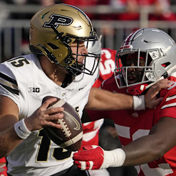Purdue Boilermakers quarterback Ryan Browne (15) is pursued by Ohio State Buckeyes defensive end Joshua Mickens (52) 