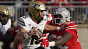 Purdue Boilermakers quarterback Ryan Browne (15) is pursued by Ohio State Buckeyes defensive end Joshua Mickens (52) 