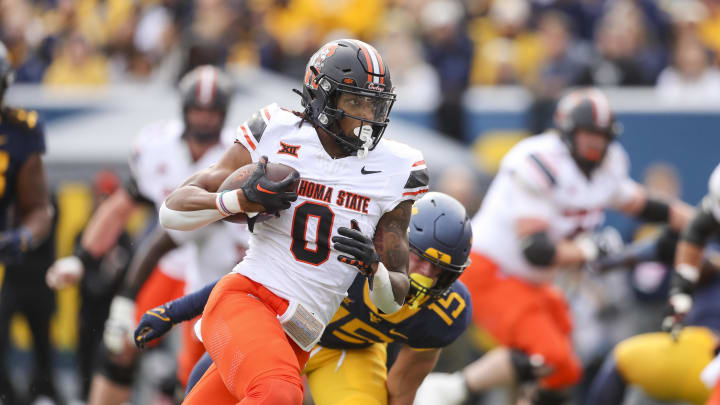 Oct 21, 2023; Morgantown, West Virginia, USA; Oklahoma State Cowboys running back Ollie Gordon II (0) runs for a touchdown during the first quarter against the West Virginia Mountaineers at Mountaineer Field at Milan Puskar Stadium. Mandatory Credit: Ben Queen-USA TODAY Sports