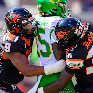 Sep 14, 2024; Corvallis, Oregon, USA; Oregon State Beavers linebacker Isaiah Chisom (9) and defensive back Josiah Johnson (30) tackle Oregon Ducks wide receiver Tez Johnson (15) after a catch during the second half at Reser Stadium. Mandatory Credit: Craig Strobeck-Imagn Images
