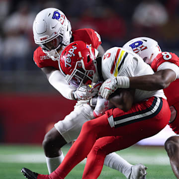 Maryland wide receiver Octavian Smith Jr. is tackled by Rutgers linebacker Dariel Djabome (8) and defensive lineman Cam Rice.