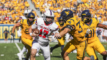 Aug 30, 2025; Morgantown, West Virginia, USA; Robert Morris Colonials quarterback Zach Tanner (17) is tackled for a loss by West Virginia Mountaineers linebacker Chase Wilson (30) during the third quarter at Milan Puskar Stadium. Mandatory Credit: Ben Queen-Imagn Images