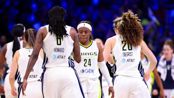 Wings guard Ogunbowale celebrates with Wings forwards Howard and Siegrist.