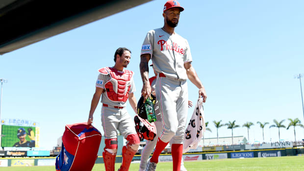 Phillies players Christopher Sanchez and Garrett Stubbs walk on the field at the Pirates' spring facility