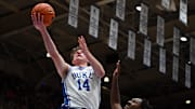 Nov 23, 2025; Durham, North Carolina, USA;  Duke Blue Devils forward Nikolas Khamenia (14) lays the ball up in front of Howard Bison guard Bryce Harris (34) during the second half at Cameron Indoor Stadium. Mandatory Credit: Rob Kinnan-Imagn Images
