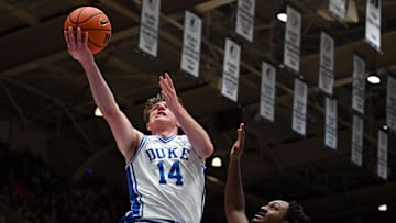 Nov 23, 2025; Durham, North Carolina, USA;  Duke Blue Devils forward Nikolas Khamenia (14) lays the ball up in front of Howard Bison guard Bryce Harris (34) during the second half at Cameron Indoor Stadium. Mandatory Credit: Rob Kinnan-Imagn Images