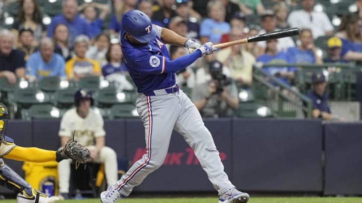 Jun 24, 2024; Milwaukee, Wisconsin, USA;  Texas Rangers second baseman Marcus Semien (2) hits a single to drive in a run during the fifth inning against the Milwaukee Brewers at American Family Field. 