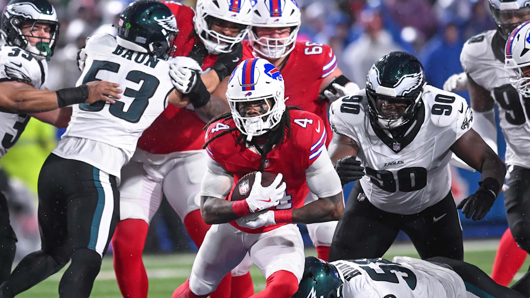 Dec 28, 2025; Orchard Park, New York, USA; Buffalo Bills running back James Cook III (4) runs past Philadelphia Eagles defensive tackle Jordan Davis (90) the second quarter at Highmark Stadium. Mandatory Credit: Mark Konezny-Imagn Images
