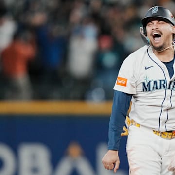 Oct 17, 2025; Seattle, Washington, USA; Seattle Mariners first baseman Josh Naylor (12) reacts after third baseman Eugenio Suarez (not pictured) hits a grand slam against the Toronto Blue Jays in the eighth inning during game five of the ALCS round for the 2025 MLB playoffs at T-Mobile Park. Mandatory Credit: Stephen Brashear-Imagn Images