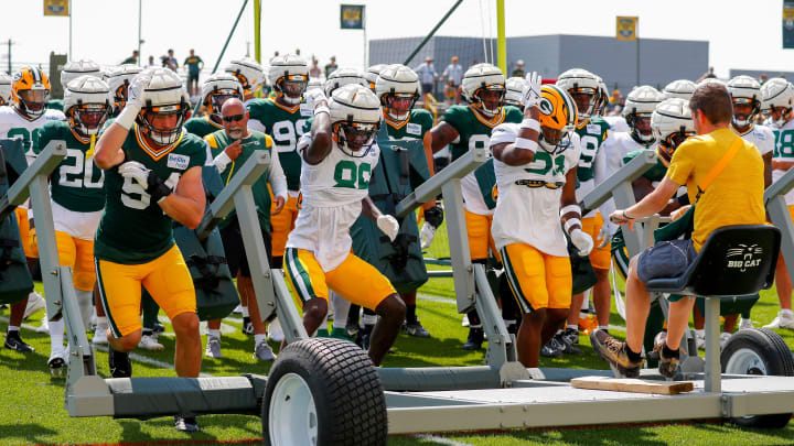 Packers linebacker Kristian Welch (54), wide receiver Grant DuBose (86) and running back Emanuel Wilson (31) work vs. a five-man sled at training camp.