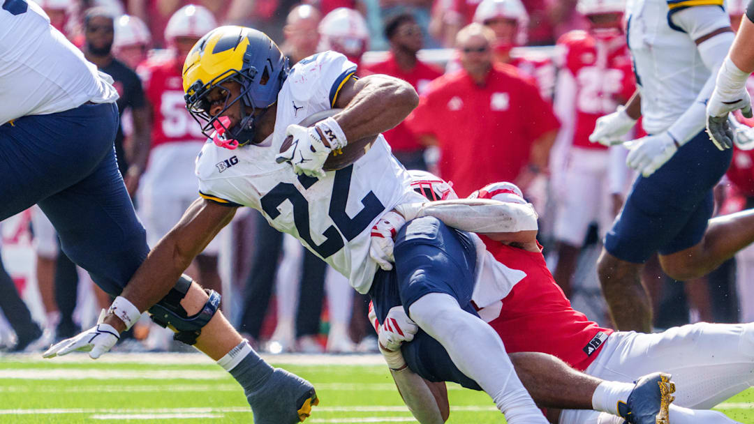 Sep 20, 2025; Lincoln, Nebraska, USA; Michigan Wolverines running back Justice Haynes (22) gets tackled by Nebraska Cornhuskers linebacker Javin Wright (0) during the second quarter at Memorial Stadium. Mandatory Credit: Dylan Widger-Imagn Images