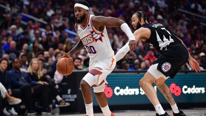 Apr 10, 2024; Los Angeles, California, USA; Phoenix Suns forward Royce O'Neale (00) moves the ball against Los Angeles Clippers guard Amir Coffey (7) during the second half at Crypto.com Arena. Mandatory Credit: Gary A. Vasquez-USA TODAY Sports