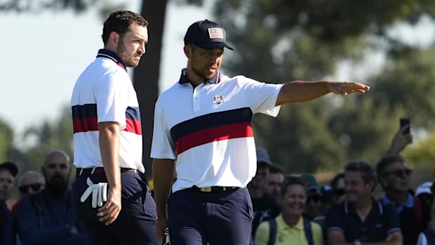 Team USA golfers Xander Schauffele (right) and Patrick Cantlay prepare for a putt during foursomes at the 2023 Ryder Cup