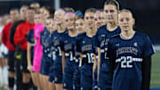 The Marist girl soccer team lines up for the Star Spangled Banner before their playoff match against Henley in Eugene Nov. 11, 2025.