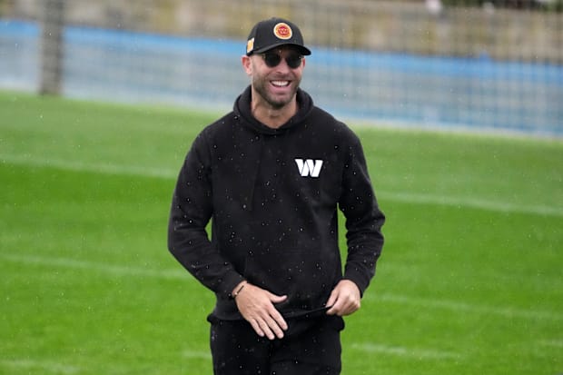 Kliff Kingsbury smiling in sunglasses and a hat.