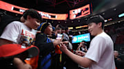Oct 24, 2025; Portland, Oregon, USA;  Portland Trail Blazers center Yang Hansen (16) gives away a pair of Li-Ning shoes to kids before Trail Blazers play Golden State Warriors Moda Center. Mandatory Credit: Jaime Valdez-Imagn Images