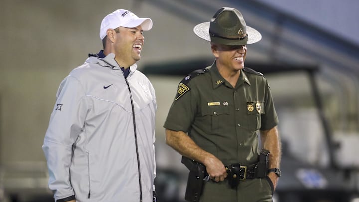Sep 9, 2023; Morgantown, West Virginia, USA; West Virginia University Athletic Director Wren Baker talks to a West Virginia State Trooper during the third quarter against the Duquesne Dukes at Mountaineer Field at Milan Puskar Stadium. Mandatory Credit: Ben Queen-Imagn Images