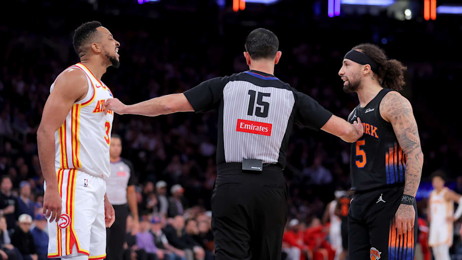 Atlanta Hawks guard CJ McCollum and New York Knicks guard Jose Alvarado exchange words while separated by referee Zach Zarba.