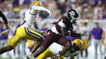 Oct 25, 2025; Baton Rouge, Louisiana, USA; Texas A&M Aggies running back Rueben Owens II (4) runs against Louisiana State Tigers cornerback Mansoor Delane (4) and defensive end Jack Pyburn (44) during the second half at Tiger Stadium. Mandatory Credit: Stephen Lew-Imagn Images