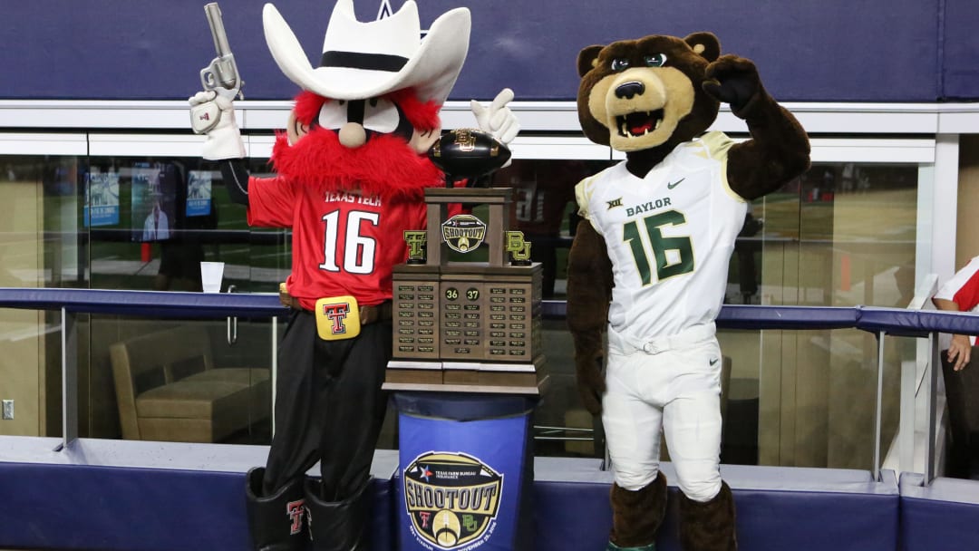 Nov 25, 2016; Arlington, TX, USA; The Texas Tech Red Raiders mascot and the Baylor Bears mascot pose with the Texas Farm Bureau Insurance Shootout trophy during the game at AT&T Stadium. Texas Tech defeated Baylor 54-35.  Mandatory Credit: Michael C. Johnson-USA TODAY Sports