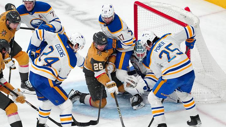 Jan 4, 2025; Las Vegas, Nevada, USA; Vegas Golden Knights right wing Alexander Holtz (26) is checked by Buffalo Sabres left wing Jason Zucker (17) in front of goaltender James Reimer (47) as defenseman Owen Power (25) collects a rebound during the third period at T-Mobile Arena. Mandatory Credit: Stephen R. Sylvanie-Imagn Images