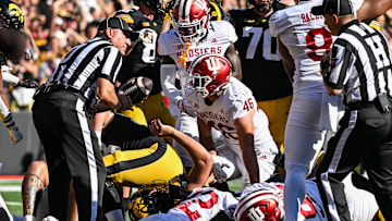 Sep 27, 2025; Iowa City, Iowa, USA; Iowa Hawkeyes quarterback Mark Gronowski (on the ground) scores on a 3 yard touchdown run as Indiana Hoosiers linebacker Isaiah Jones (46) looks on during the second quarter at Kinnick Stadium. Mandatory Credit: Jeffrey Becker-Imagn Images