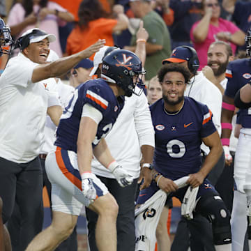 Oct 12, 2024; Charlottesville, Virginia, USA; Virginia Cavaliers head coach Tony Elliott (center) celebrates after Virginia Cavaliers safety Ethan Minter (30) intercepts the ball against the Louisville Cardinals during the second half at Scott Stadium. Mandatory Credit: Amber Searls-Imagn Images