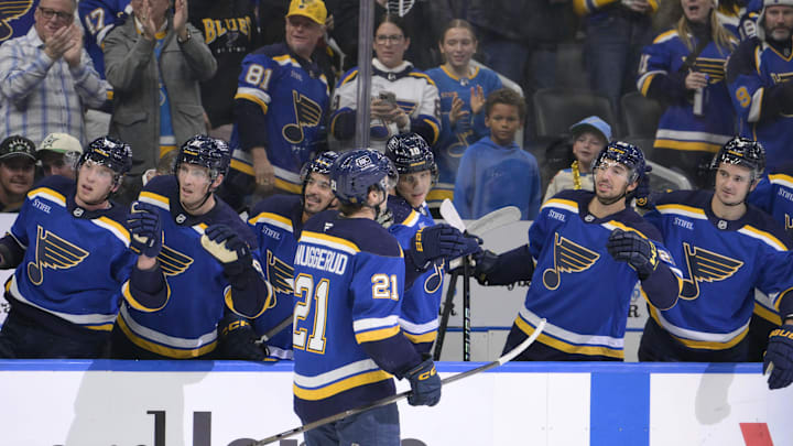 Oct 18, 2025; St. Louis, Missouri, USA; St. Louis Blues right wing Jimmy Snuggerud (21) is congratulated by teammates after scoring against the Dallas Stars during the second period at Enterprise Center. Mandatory Credit: Jeff Le-Imagn Images