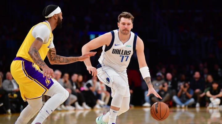 Nov 22, 2023; Los Angeles, California, USA; Dallas Mavericks guard Luka Doncic (77) moves the ball against Los Angeles Lakers forward Anthony Davis (3) during the first half at Crypto.com Arena. Mandatory Credit: Gary A. Vasquez-USA TODAY Sports