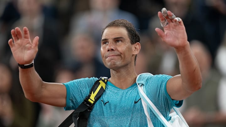 Rafael Nadal waves to the French Open crowd after a loss.