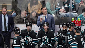 Feb 17, 2024; San Jose, California, USA; San Jose Sharks head coach David Quinn (center) talks to