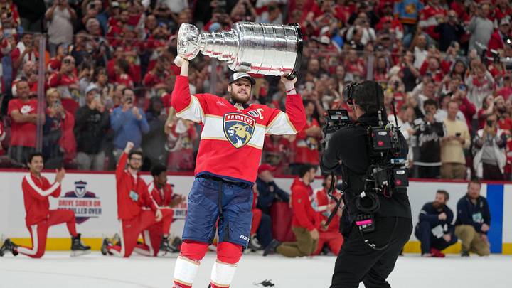 Jun 17, 2025; Sunrise, Florida, USA; Florida Panthers center Aleksander Barkov (16) hoists the Stanley Cup after winning game six of the 2025 Stanley Cup Final against the Edmonton Oilers at Amerant Bank Arena. Mandatory Credit: Jim Rassol-Imagn Images