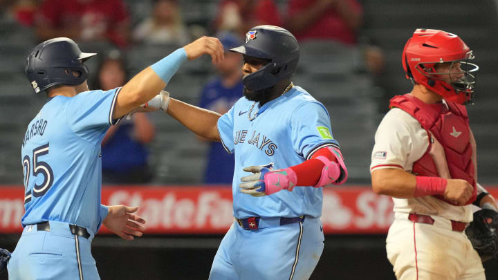 Toronto Blue Jays first baseman Vladimir Guerrero Jr. (27) celebrates with left fielder Daulton Varsho (25) after hitting a two-run home run in the eighth inning as Los Angeles Angels catcher Matt Thaiss (21) watches at Angel Stadium on Aug 14.