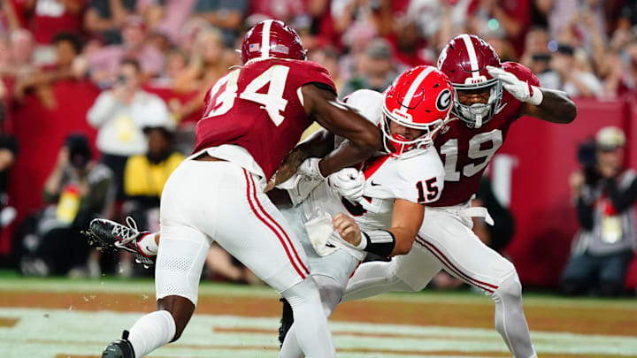 Sep 28, 2024; Tuscaloosa, Alabama, USA;  Georgia Bulldogs quarterback Carson Beck (15) is hit in the end zone by Alabama Crimson Tide linebacker Que Robinson (34) and linebacker Keanu Koht (19) after throwing a pass during the first half at Bryant-Denny Stadium. Mandatory Credit: John David Mercer-Imagn Images