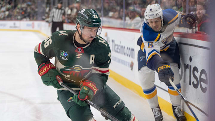 Jan 7, 2025; Saint Paul, Minnesota, USA; Minnesota Wild right wing Mats Zuccarello (36) plays the puck in the corner away from St. Louis Blues defenseman Philip Broberg (6) in the first period at Xcel Energy Center. Mandatory Credit: Matt Blewett-Imagn Images