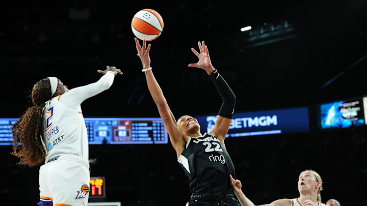 Oct 3, 2025; Las Vegas, Nevada, USA; Las Vegas Aces center A'ja Wilson (22) reaches for a rebound between Phoenix Mercury guard Kahleah Copper (2) and Phoenix Mercury guard Sami Whitcomb (33) during the fourth quarter of game one of the 2025 WNBA Finals at Michelob Ultra Arena. Mandatory Credit: Stephen R. Sylvanie-Imagn Images