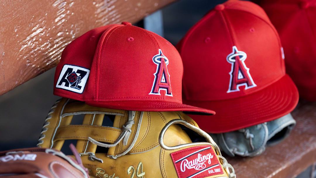 Feb 28, 2025; Phoenix, Arizona, USA; Detailed view of the Los Angeles Angels logo on a hat in the dugout during a spring training game at Camelback Ranch-Glendale. Mandatory Credit: Mark J. Rebilas-Imagn Images