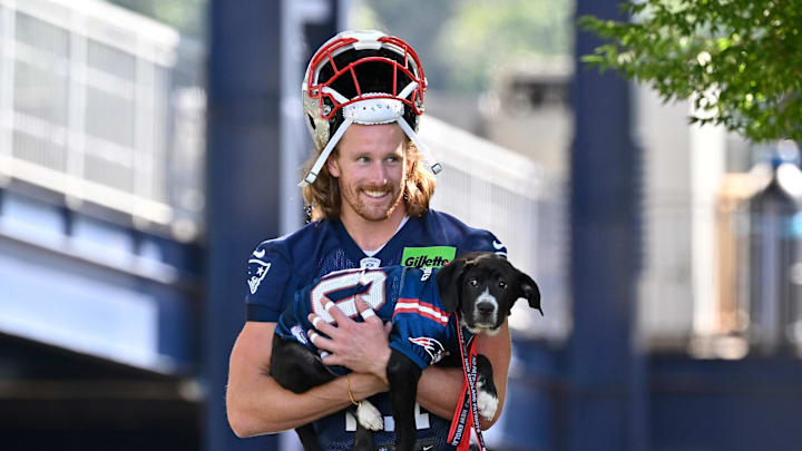 Jul 23, 2025; Foxborough, MA, USA; New England Patriots safety Brenden Schooler (41) delivers a puppy to a local family as part of the Patriots pet adoption event before training camp at Gillette Stadium. Mandatory Credit: Eric Canha-Imagn Images