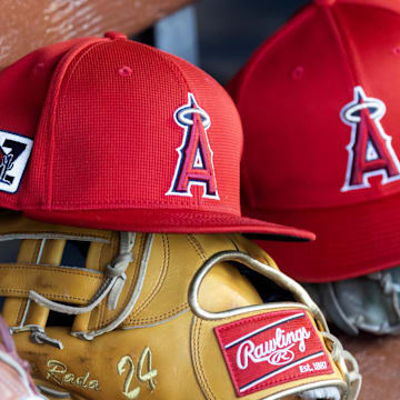 Feb 28, 2025; Phoenix, Arizona, USA; Detailed view of the Los Angeles Angels logo on a hat in the dugout during a spring training game at Camelback Ranch-Glendale. Mandatory Credit: Mark J. Rebilas-Imagn Images