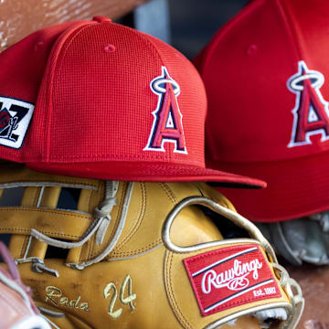 Feb 28, 2025; Phoenix, Arizona, USA; Detailed view of the Los Angeles Angels logo on a hat in the dugout during a spring training game at Camelback Ranch-Glendale. Mandatory Credit: Mark J. Rebilas-Imagn Images