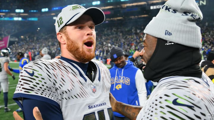Seahawks quarterback Sam Darnold celebrates with Jalen Milroe after leading Seattle to an overtime victory over the Rams on Thursday night to clinch a playoff berth.