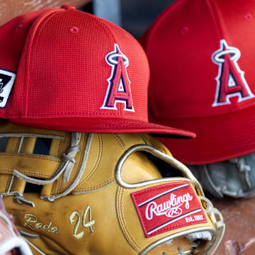 Feb 28, 2025; Phoenix, Arizona, USA; Detailed view of the Los Angeles Angels logo on a hat in the dugout during a spring training game at Camelback Ranch-Glendale. Mandatory Credit: Mark J. Rebilas-Imagn Images