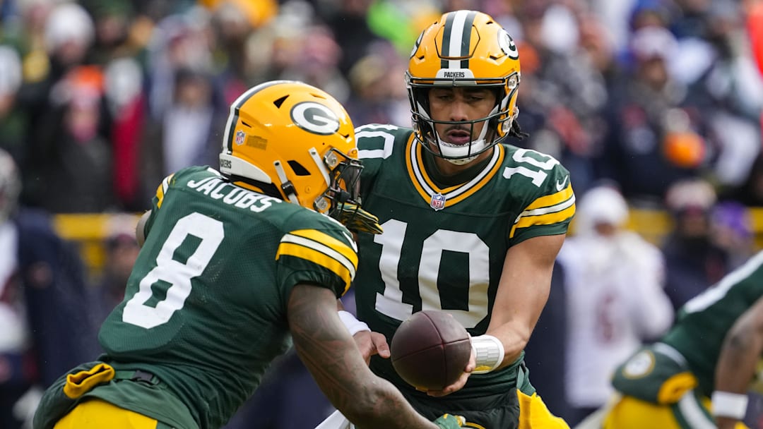 Jan 5, 2025; Green Bay, Wisconsin, USA;  Green Bay Packers quarterback Jordan Love (10) hands the football off to running back Josh Jacobs (8) during the first quarter against the Chicago Bears at Lambeau Field. Mandatory Credit: Jeff Hanisch-Imagn Images