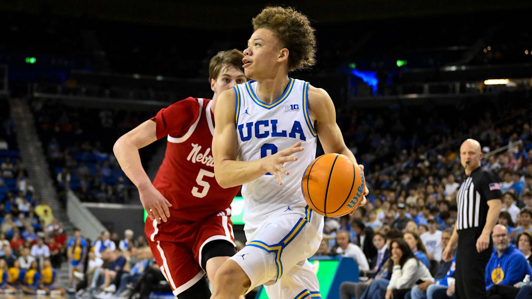 Mar 3, 2026; Los Angeles, California, USA; UCLA Bruins guard Trent Perry (0) drives the baseline past Nebraska Cornhuskers forward Braden Frager (5) during the first half at Pauley Pavilion presented by Wescom Financial. Mandatory Credit: Robert Hanashiro-Imagn Images