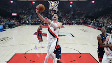 Mar 17, 2025; Portland, Oregon, USA; Portland Trail Blazers small forward Deni Avdija (8) lays up a shot past Washington Wizards small forward Khris Middleton (32) during the first half at Moda Center. Mandatory Credit: Soobum Im-Imagn Images