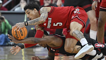 Mar 8, 2025; Louisville, Kentucky, USA;  Louisville Cardinals guard Terrence Edwards Jr. (5) scrambles for a loose ball with Stanford Cardinal guard Jaylen Blakes (21) during the first half at KFC Yum! Center. Mandatory Credit: Jamie Rhodes-Imagn Images