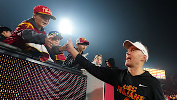 Nov 29, 2025; Los Angeles, California, USA; Southern California Trojans head coach Lincoln Riley celebrates with fans after the game against the UCLA Bruins at United Airlines Field at Los Angeles Memorial Coliseum. Mandatory Credit: Kirby Lee-Imagn Images