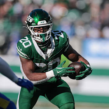 Dec 22, 2024; East Rutherford, New Jersey, USA; New York Jets running back Breece Hall (20) carries the ball asLos Angeles Rams safety Jaylen McCollough (39) pursues during the first half at MetLife Stadium. Mandatory Credit: Vincent Carchietta-Imagn Images